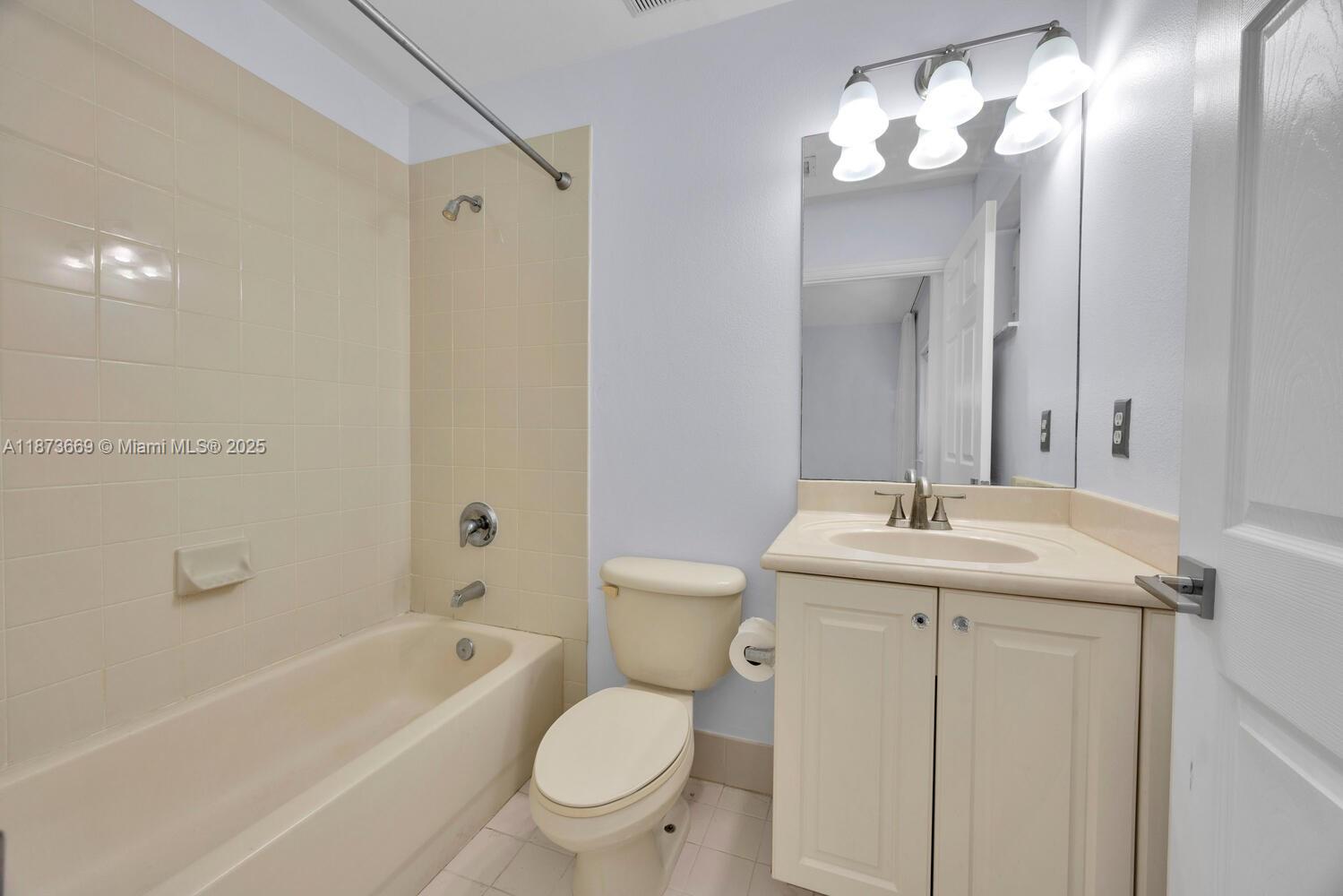 2641 Southwest 83rd Terrace, Unit 104 Miramar, FL 33025 - Photo 23 of 30 a bathroom with a toilet sink and mirror
