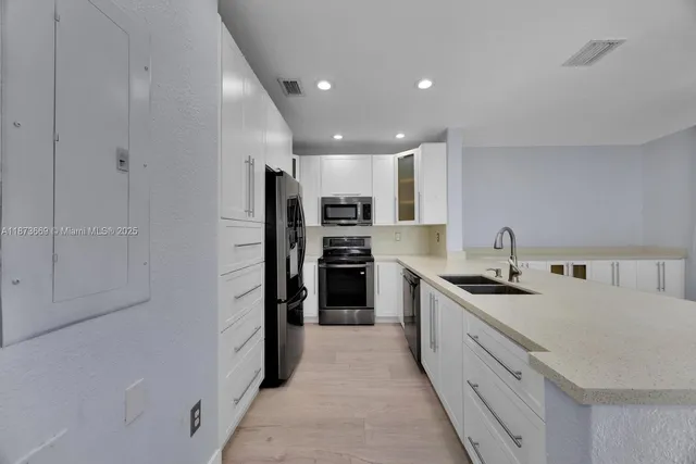 a kitchen with stainless steel appliances granite countertop a refrigerator and a sink