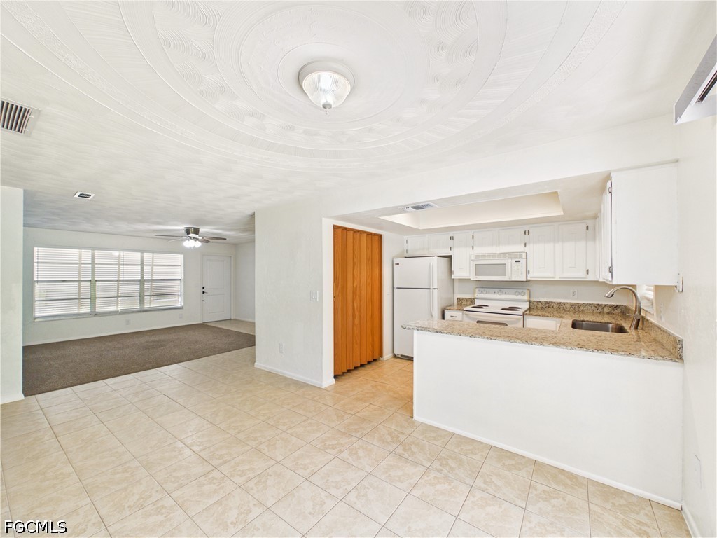 18541 Iris Road Fort Myers, FL 33967 - Photo 12 of 18 a kitchen with stainless steel appliances granite countertop a refrigerator and a stove top oven