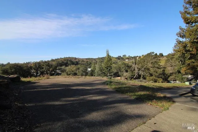 a view of dirt road with a building in the background