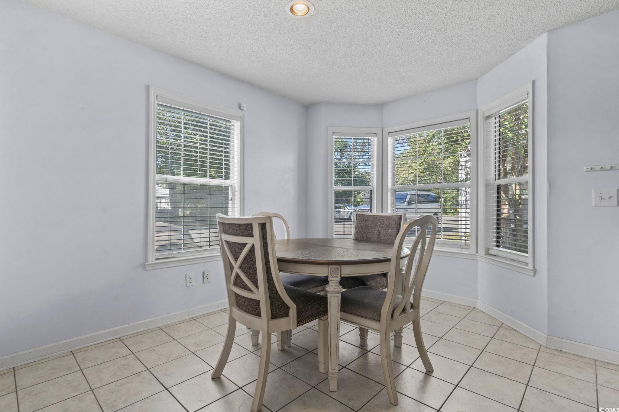 712 67th Avenue North, Unit 2A Myrtle Beach, SC 29572 - Photo 12 of 30 Dining room featuring light tile patterned floors and a textured ceiling