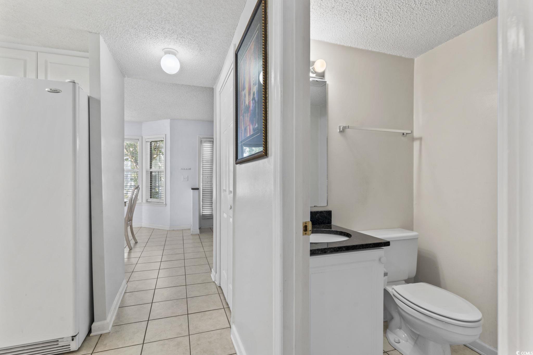 712 67th Avenue North, Unit 2A Myrtle Beach, SC 29572 - Photo 22 of 30 Bathroom with light tile patterned floors, vanity, and a textured ceiling