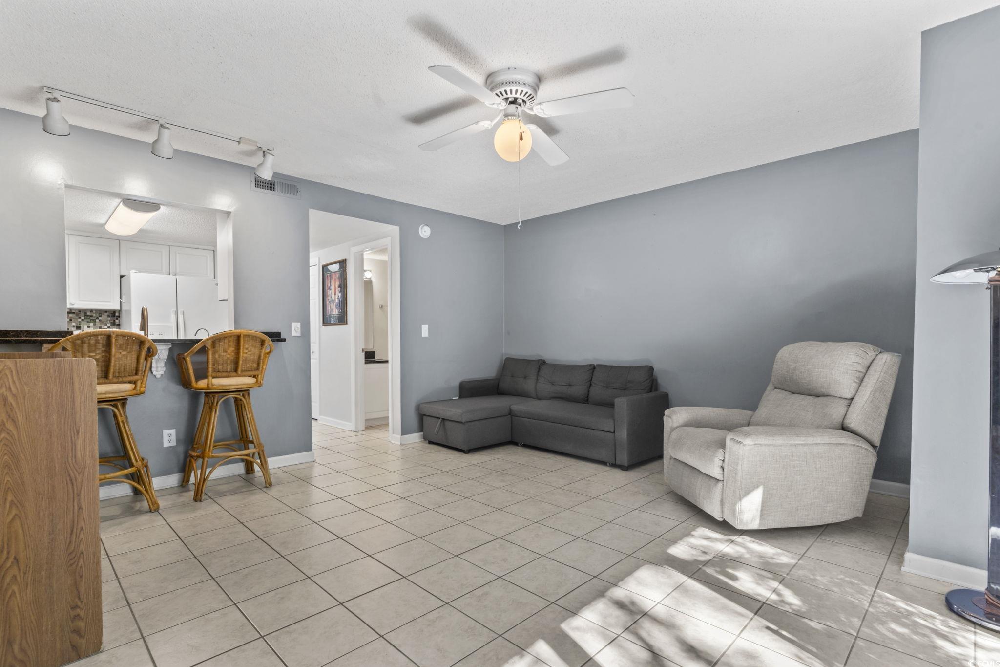 712 67th Avenue North, Unit 2A Myrtle Beach, SC 29572 - Photo 9 of 30 Living area with ceiling fan, light tile patterned floors, track lighting, and a textured ceiling