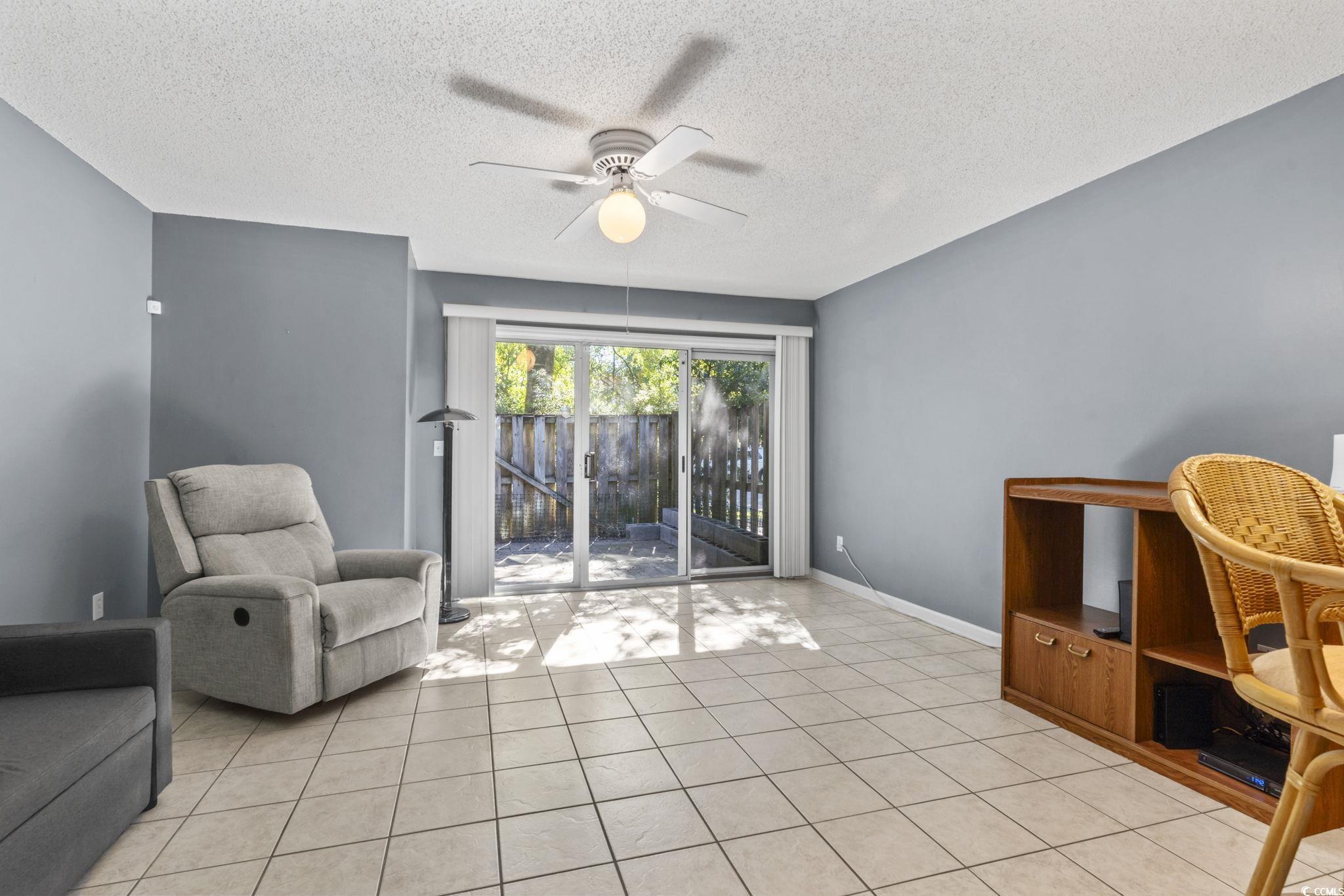 712 67th Avenue North, Unit 2A Myrtle Beach, SC 29572 - Photo 10 of 30 Living area with a ceiling fan, light tile patterned flooring, and a textured ceiling
