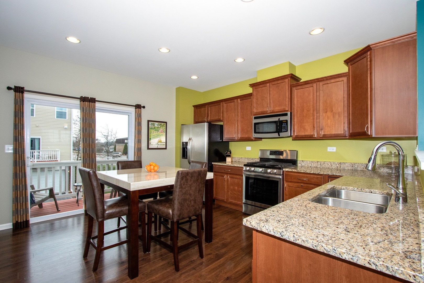 10346 Kerry Ridge Court Chicago Ridge, IL 60415 - Photo 2 of 20 a kitchen with stainless steel appliances granite countertop a stove top oven a sink dishwasher a dining table and chairs with wooden floor