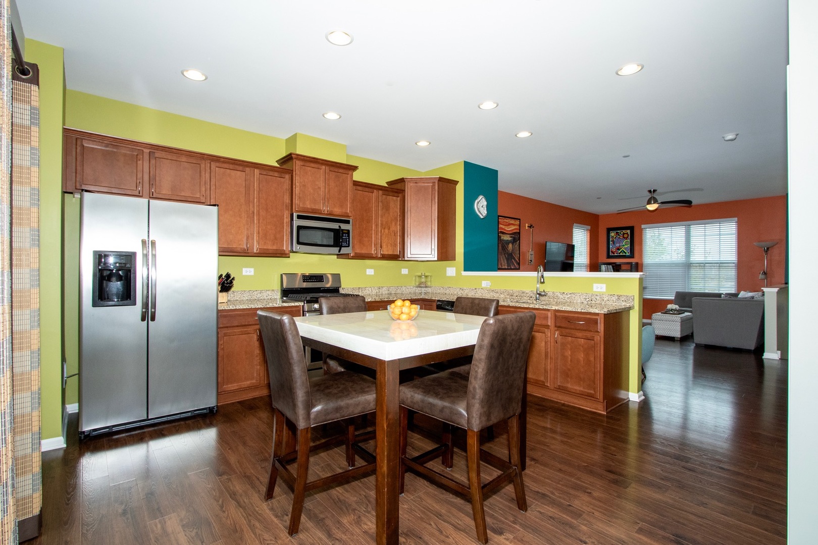 10346 Kerry Ridge Court Chicago Ridge, IL 60415 - Photo 3 of 20 a kitchen with stainless steel appliances granite countertop a refrigerator a sink dishwasher a stove and a dining table with wooden floor
