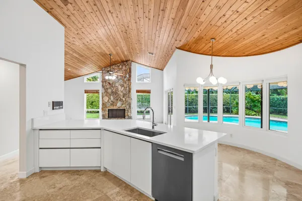 a large white kitchen with a large window and stainless steel appliances