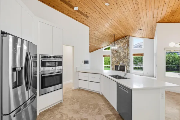 a kitchen with stainless steel appliances a sink a stove and a refrigerator
