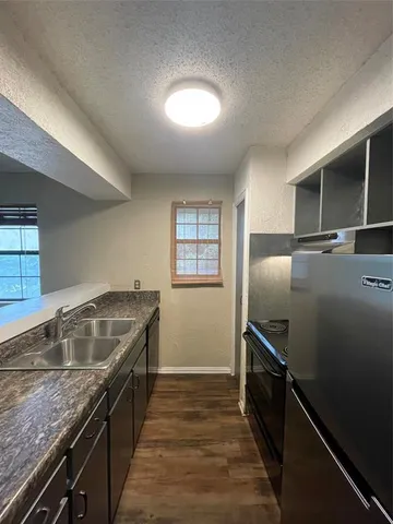 a kitchen with granite countertop a refrigerator and a sink