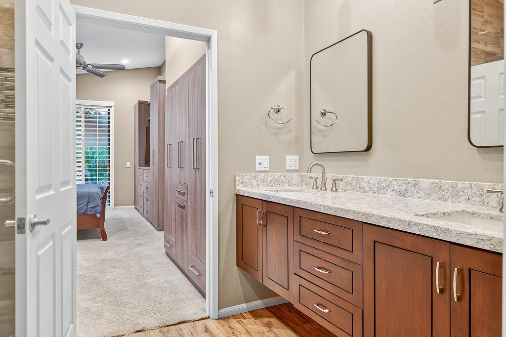 38019 Crocus Lane Palm Desert, CA 92211 - Photo 19 of 28 a bathroom with a granite countertop sink a mirror and a shower