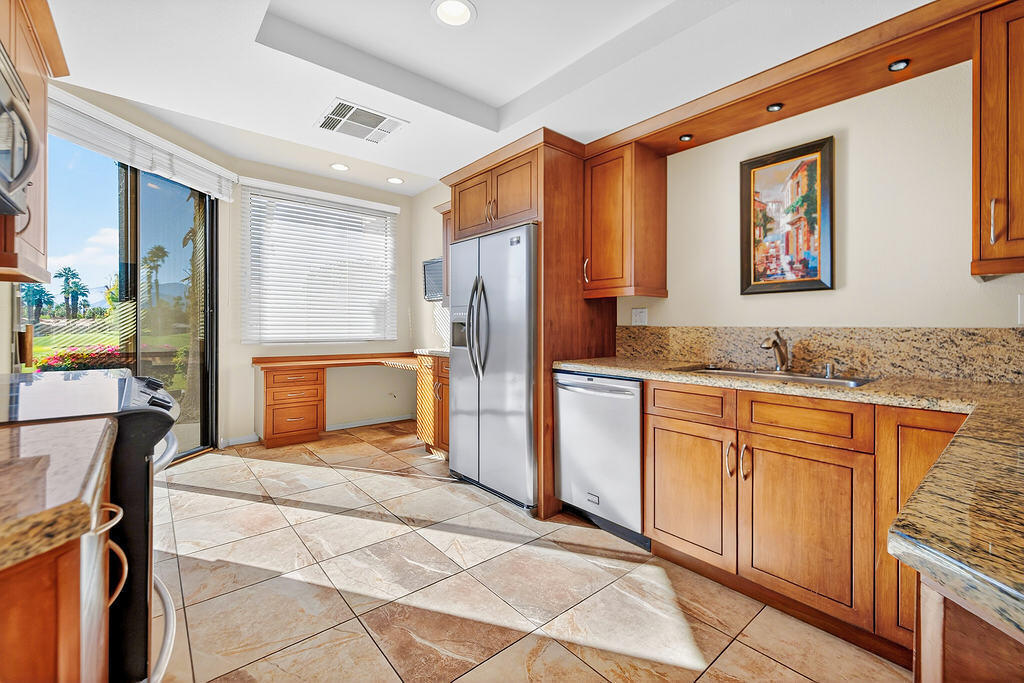 38019 Crocus Lane Palm Desert, CA 92211 - Photo 6 of 28 a kitchen with granite countertop cabinets and refrigerator