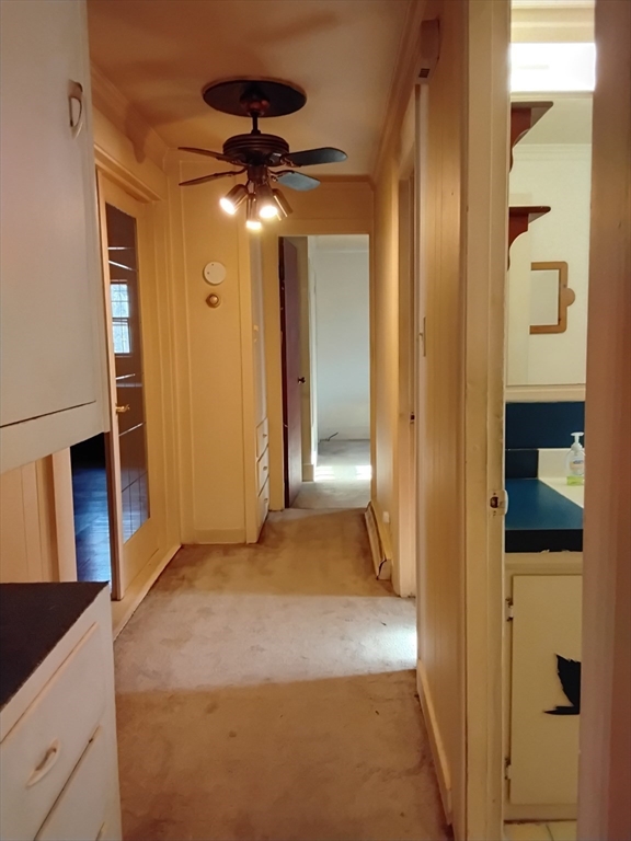 419 Spring Street Hanson, MA 02341 - Photo 15 of 26 a view of a hallway with wooden floor and chandelier