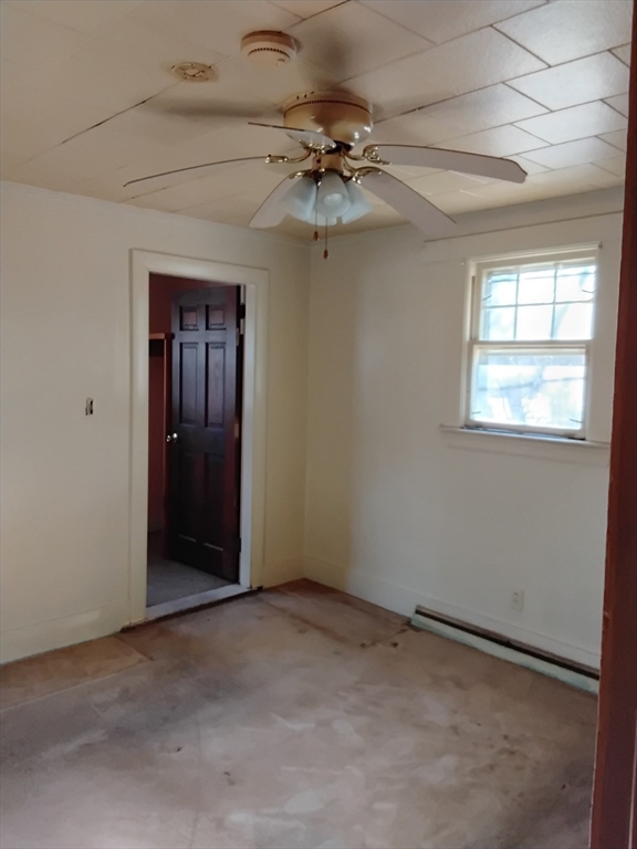 419 Spring Street Hanson, MA 02341 - Photo 17 of 26 an empty room with a chandelier fan and windows