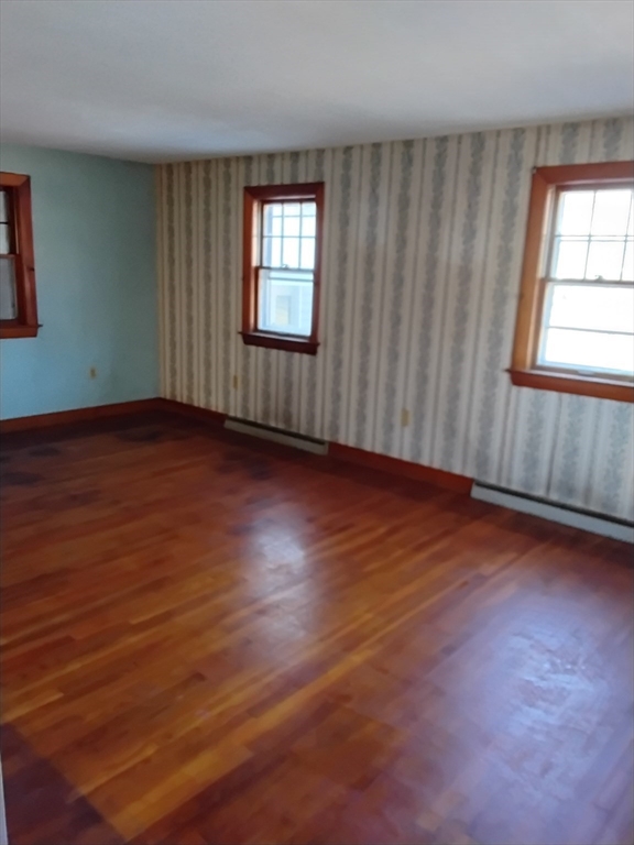 419 Spring Street Hanson, MA 02341 - Photo 21 of 26 an empty room with wooden floor and windows