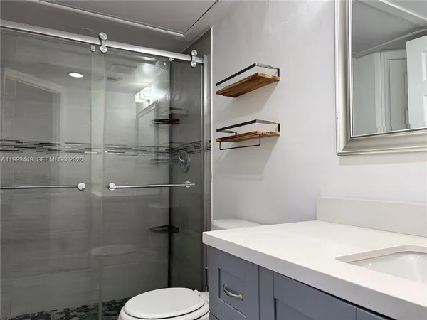 a bathroom with a shower toilet and sink