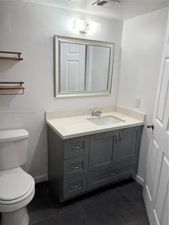 a bathroom with a sink toilet and mirror