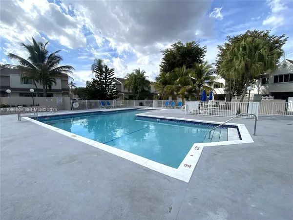 a view of a swimming pool with a patio and a yard