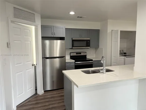 a kitchen with kitchen island a counter top space stainless steel appliances and cabinets