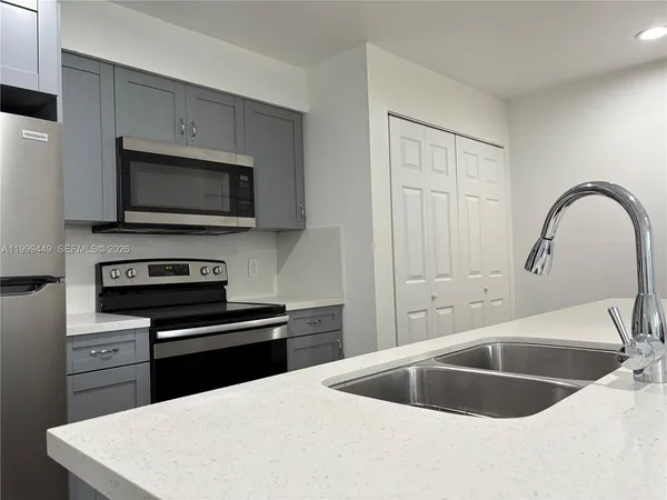 a kitchen with sink a microwave and stove