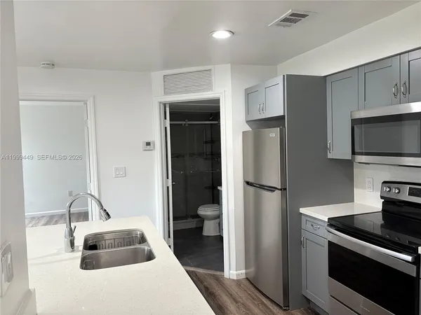 a kitchen with a refrigerator and a sink