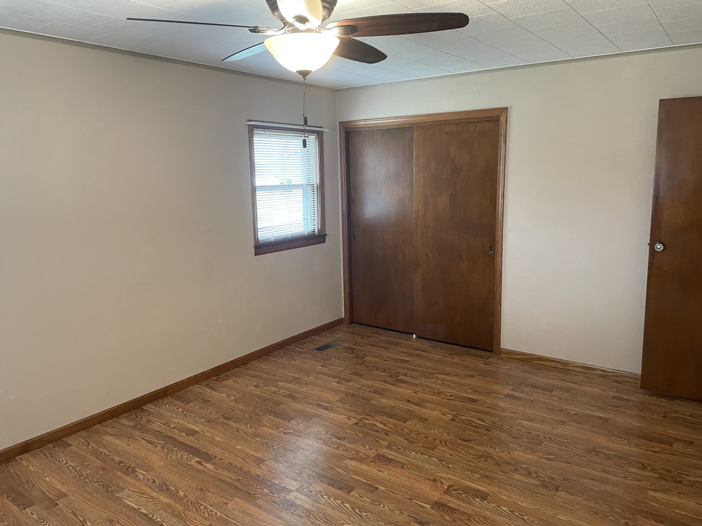 205 North 3rd Street Danforth, IL 60930 - Photo 7 of 17 an empty room with a chandelier fan and wooden floor