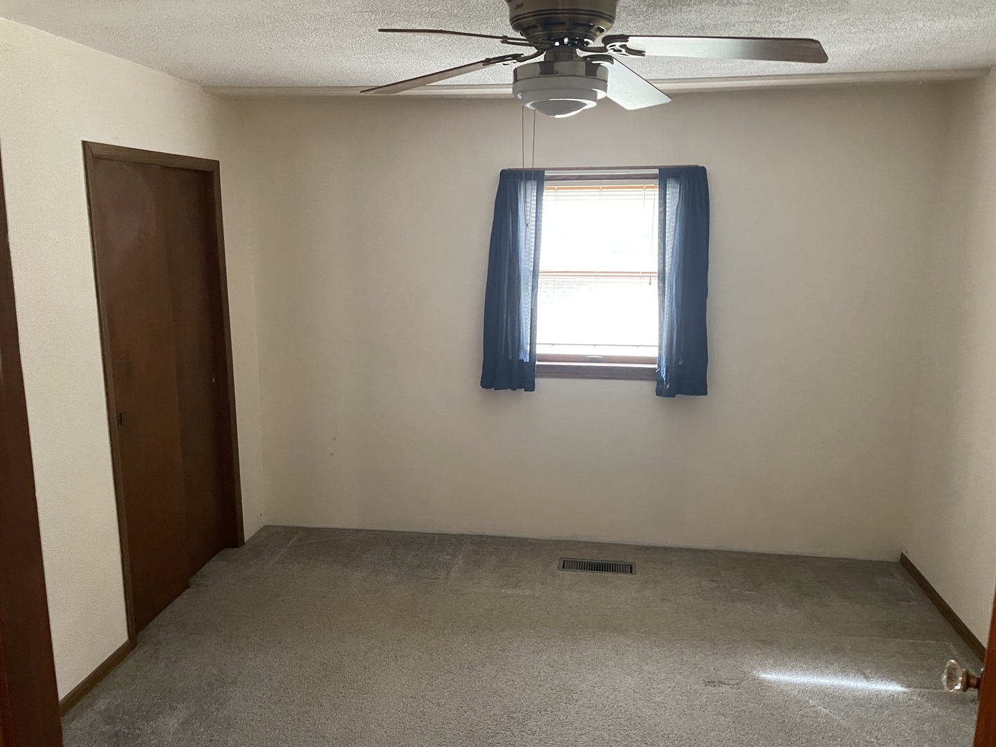 205 North 3rd Street Danforth, IL 60930 - Photo 8 of 17 an empty room with a chandelier fan and windows