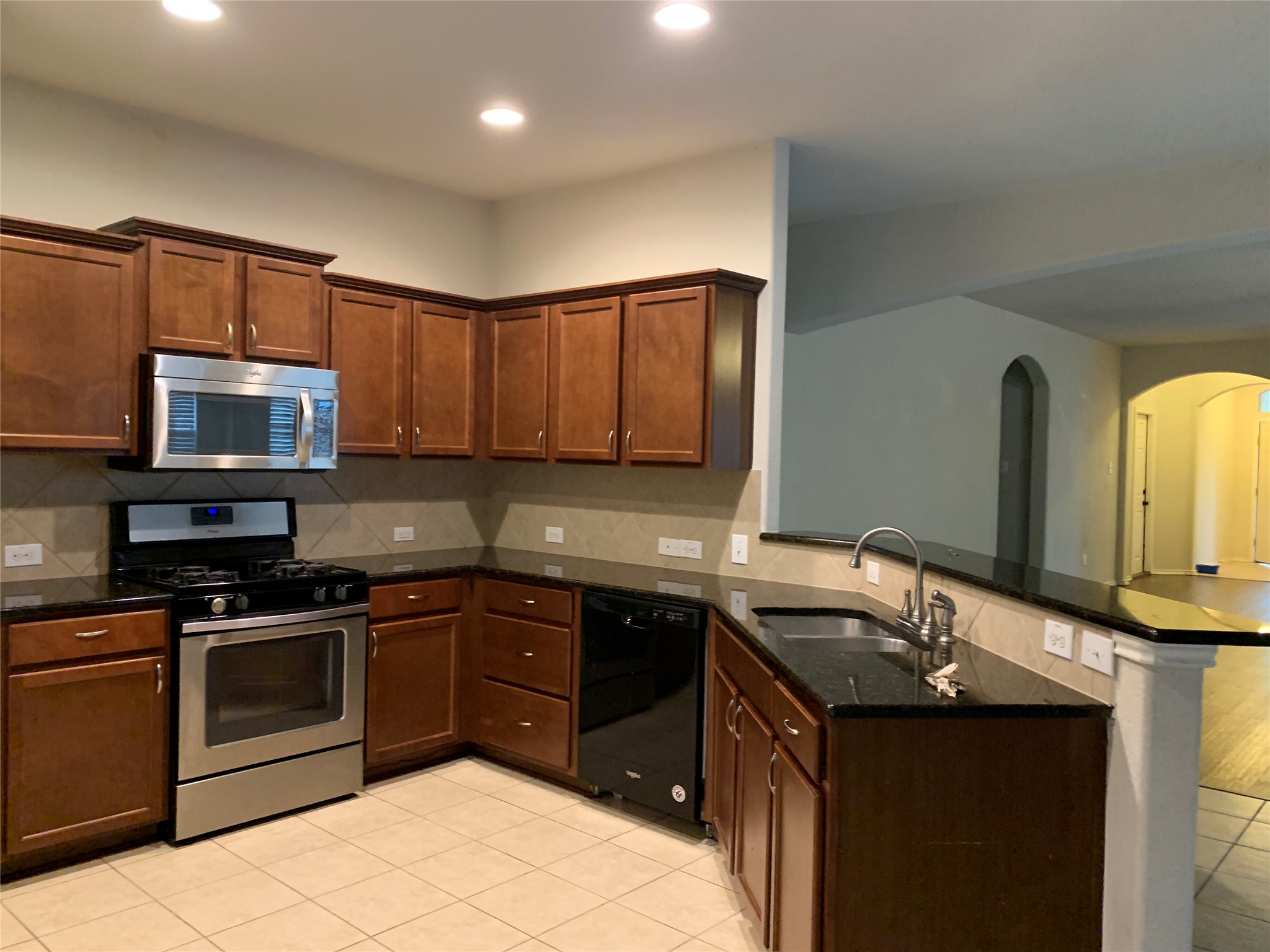 117 Antelope Plains Road Buda, TX 78610 - Photo 5 of 24 Rich wood cabinetry paired with dark stone countertops anchors this functional kitchen space.