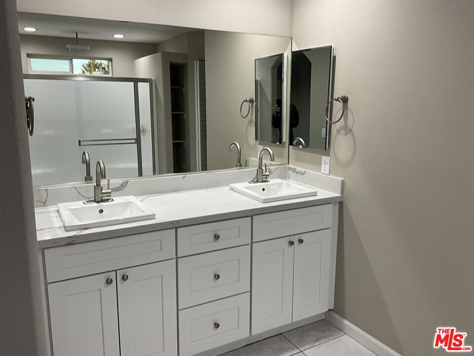 13033 Casco Road Apple Valley, CA 92308 - Photo 9 of 14 a bathroom with double sink and a mirror