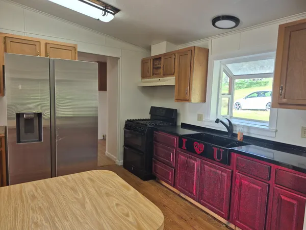 a kitchen with stainless steel appliances granite countertop a refrigerator and a sink
