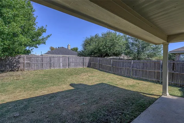 a view of a backyard with wooden fence