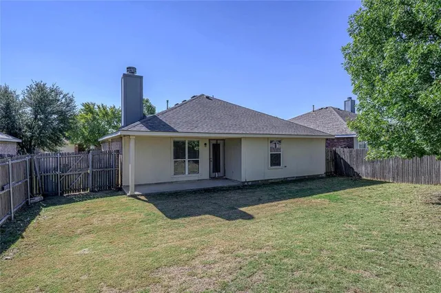 a view of a house with wooden fence and a fence