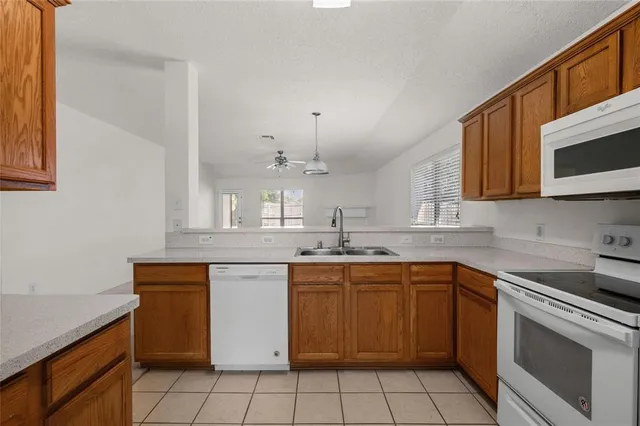 a kitchen with a sink stove top oven and microwave