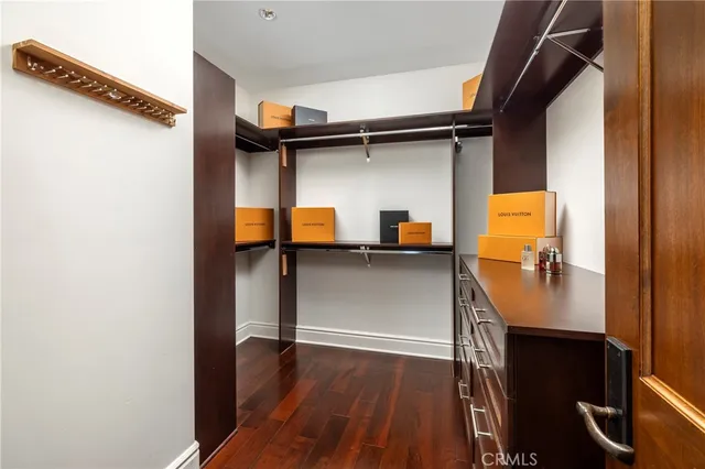 a view of a hallway with wooden floor and a bathroom