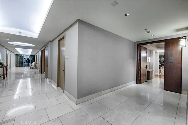 a view of a hallway with wooden floor and a living room