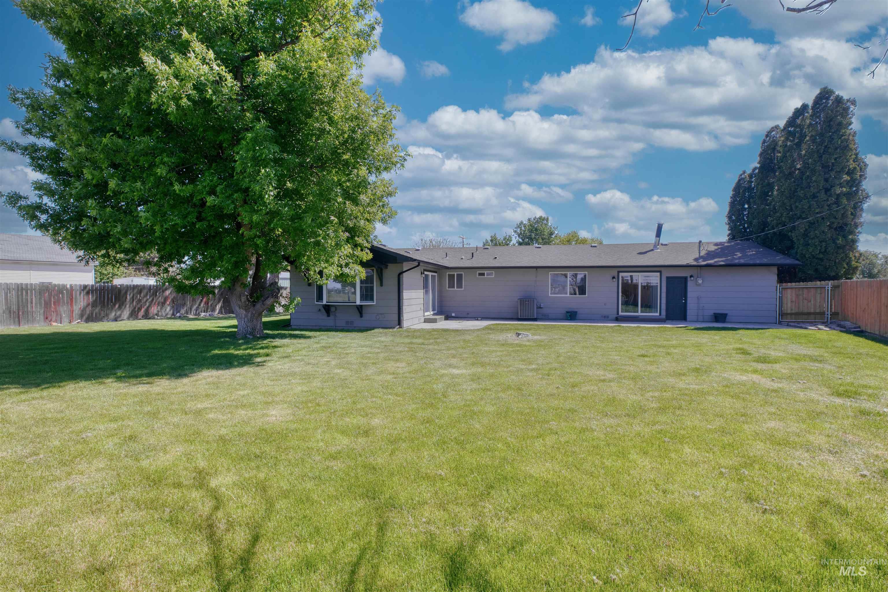 20803 Friends Road Greenleaf, ID 83626 - Photo 25 of 39 Expansive backyard with a manicured lawn, mature shade tree, and privacy fencing