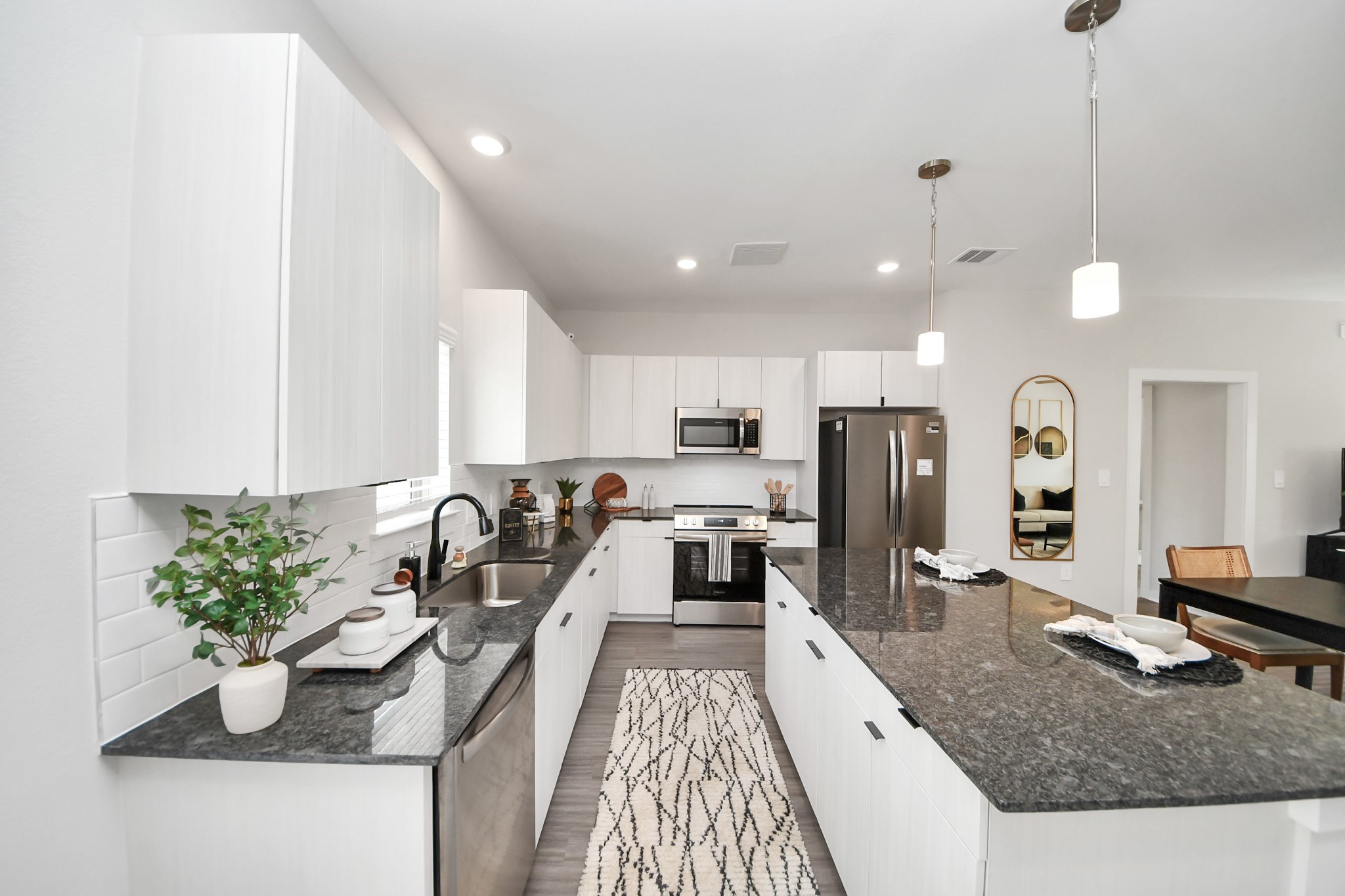 7711 Longmire Road, Unit 2 Conroe, TX 77304 - Photo 47 of 48 Boasting luxury finishes-stylish Island kitchen,granite counters,subway tile backsplash,ample custom cabinet space,stainless appliances,refrigerator,full size washer&dryer included,wood-like flooring throughout,open concept floor plan.