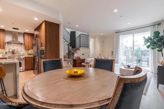 a kitchen with sink refrigerator dining table and chairs