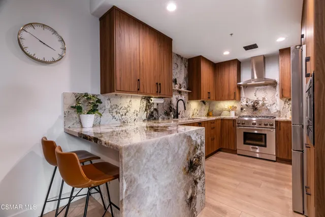 a kitchen with granite countertop a table chairs stove and cabinets