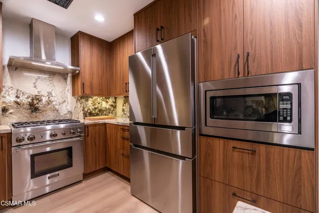 a kitchen with stainless steel appliances wooden floor sink and stove top oven