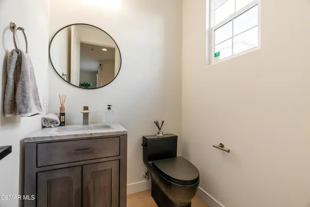 a bathroom with a granite countertop toilet sink and mirror