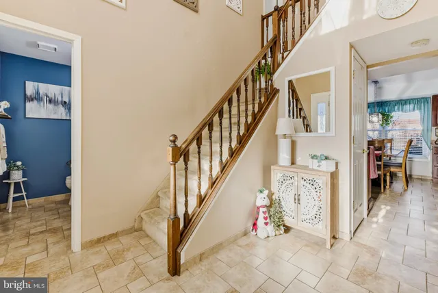 a view of staircase with lots of frames on wall and a window