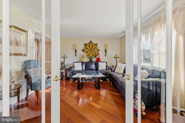 a living room with furniture wooden floor and a large window