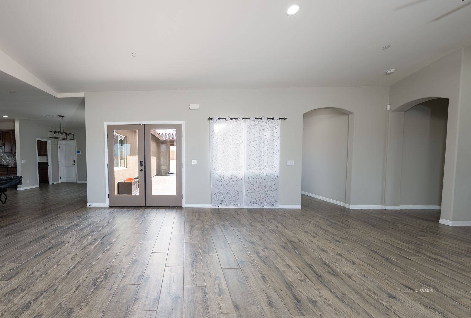 133 Rancho Del Cerro Ridgecrest, CA 93555 - Photo 7 of 50 a view of an empty room with window and wooden floor