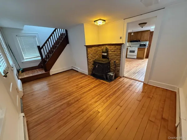 a view of a livingroom with wooden floor and stairs