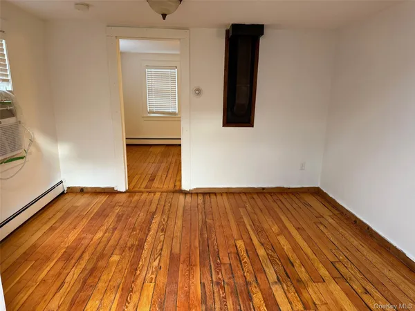 a view of a room with wooden floor and electronic appliances