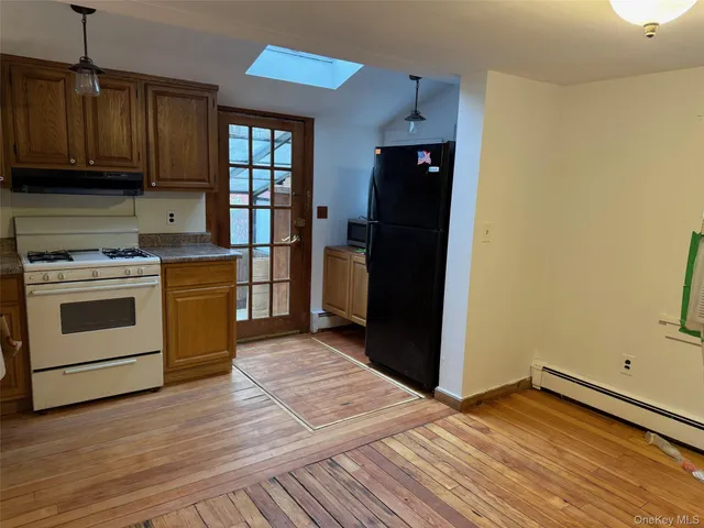 a kitchen with a wooden floor and a refrigerator