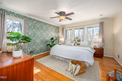 a bedroom with a large bed and a potted plant