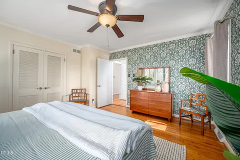 a bedroom with a bed chandelier and a window