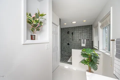 a view of a hallway to potted plants and wooden floor