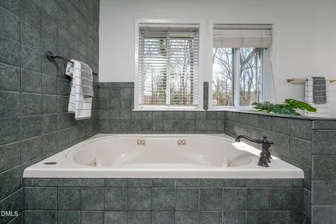 a bath tub sitting in a bathroom next to a window